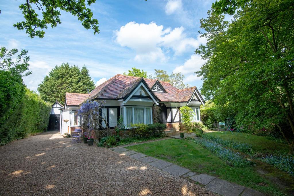 una pequeña casa con una entrada de grava en Pinewood Cottage Deluxe Self Catering Apartments, en Lyndhurst