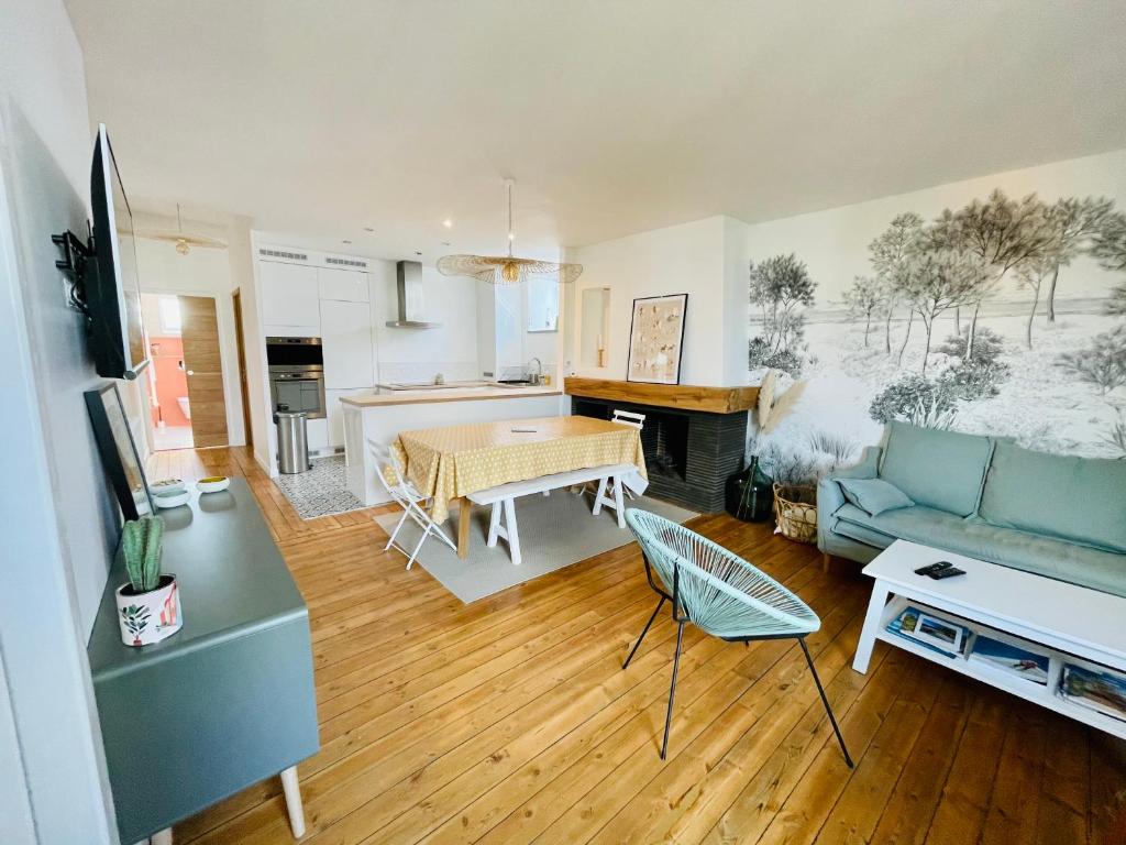 ein Wohnzimmer mit Sofa und Tisch in der Unterkunft Appartement avec balcon au coeur de la Baule in La Baule