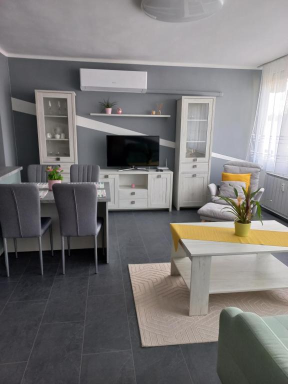 a living room with a table and a dining room at Krisztina Apartman in Salgótarján