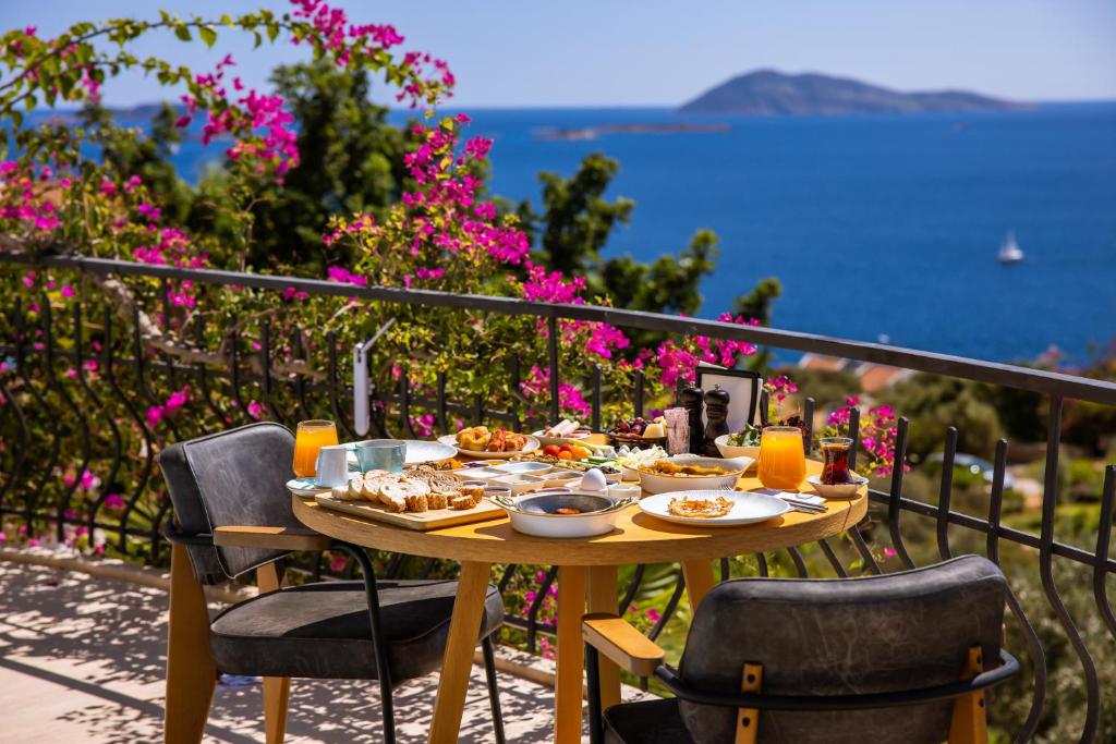 a table with food on a balcony with a view of the ocean at Hill House Adult Only in Kaş