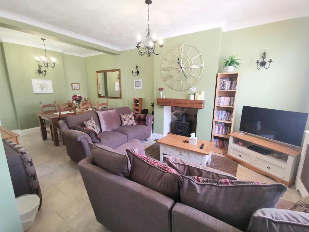 a living room with two couches and a tv at The Bridge Cottage in Llanrwst