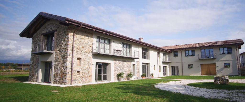 ein großes Haus mit einem Rasenplatz davor in der Unterkunft Il Fienile in Fagagna