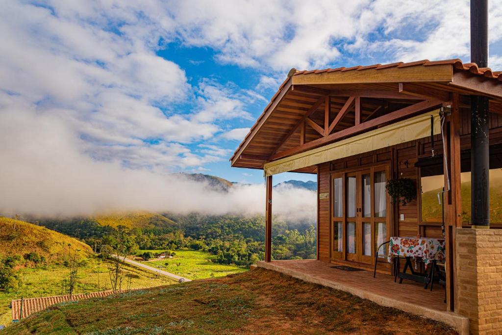 a house with a table and a view of a valley at Pousada Capim Limão in Monteiro Lobato