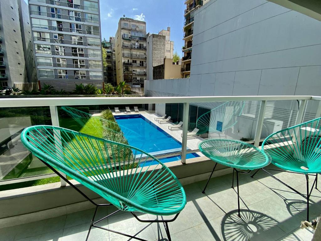 a balcony with two chairs and a swimming pool at Palermo Soho Trendy Studio II in Buenos Aires