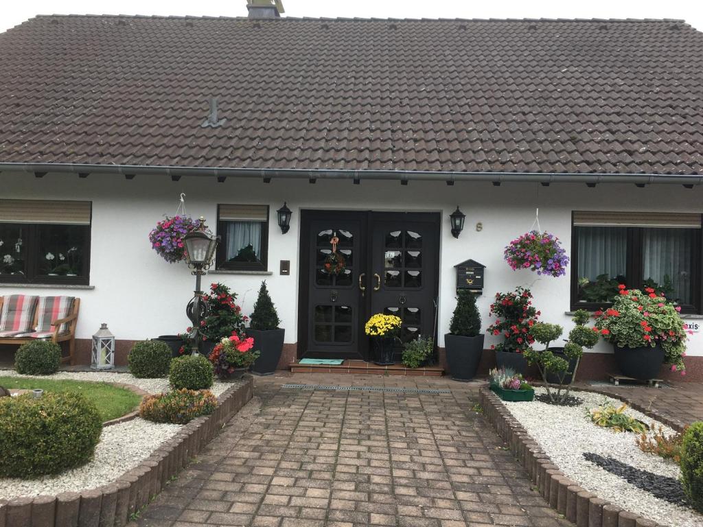 una casa blanca con flores delante en Haus Sonnenschein, en Holzbach