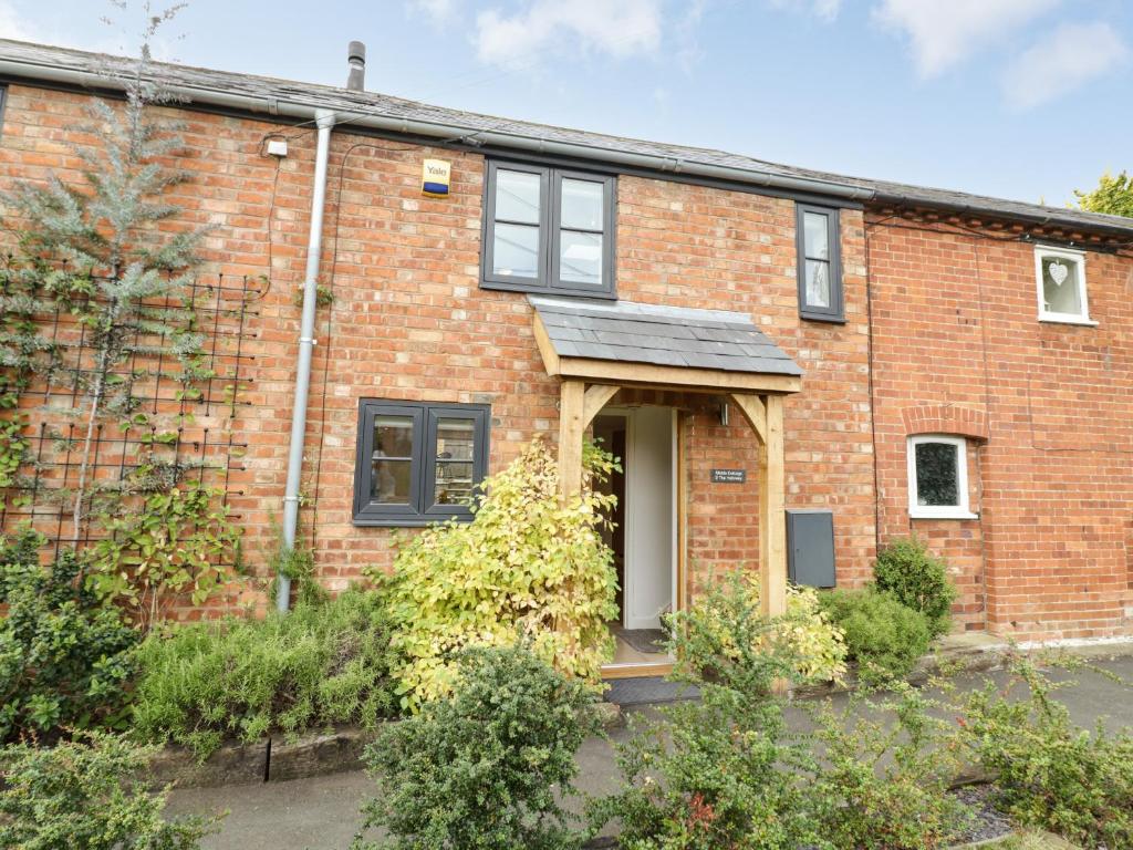 a red brick house with a white door at Middle Cottage in Southam