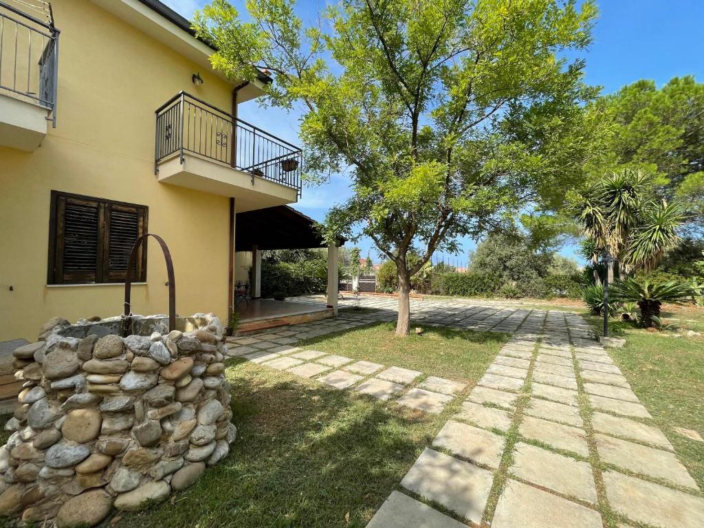 uma casa com uma parede de pedra e uma varanda em Villa Gc em Altavilla Milicia