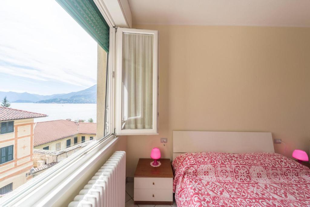a bedroom with a bed and a large window at Casa Vista Cipressi in Varenna