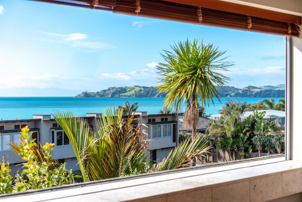 a window with a view of the ocean and buildings at The Sands - Apartment 19 in Onetangi