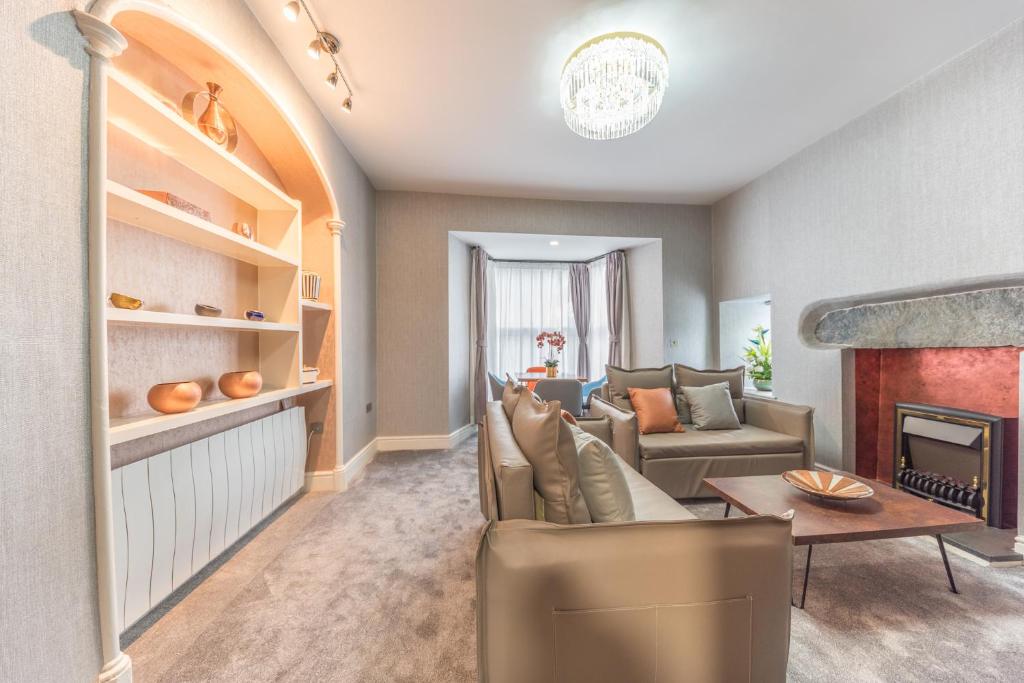 a living room with a couch and a fireplace at The Old Stamp House Apartment- Central Village Location Rooms Priced Based on Number of Guests in Ambleside