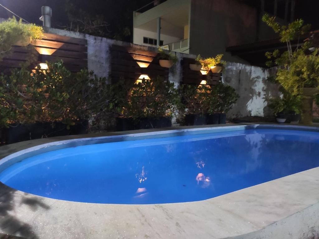 a large blue swimming pool in a backyard at night at CASAMAR Lucena in Lucena