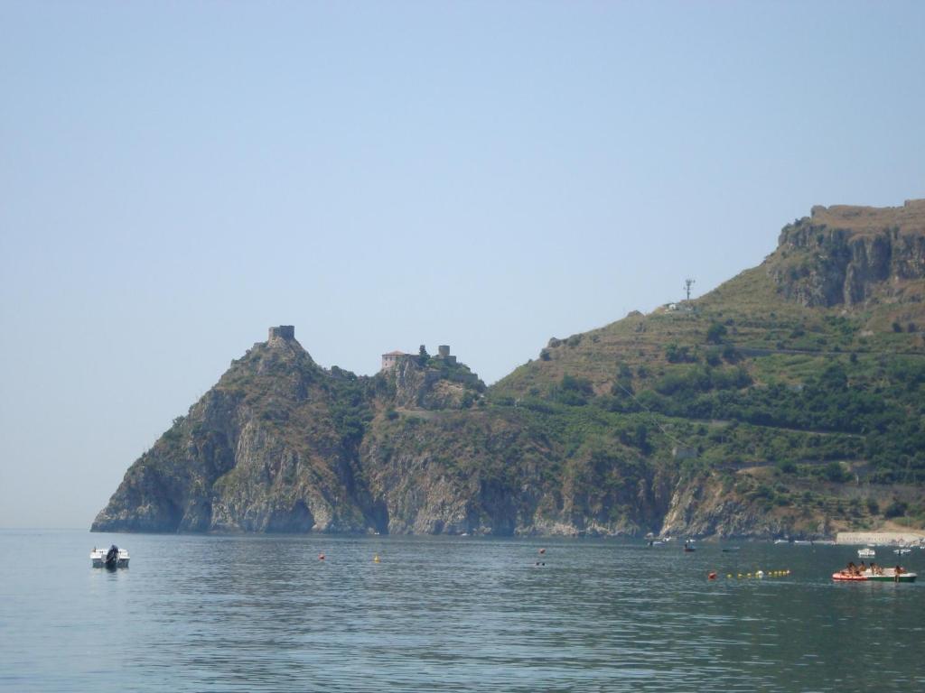 un grupo de barcos en el agua con montañas en San Giacomo, en SantʼAlessio Siculo