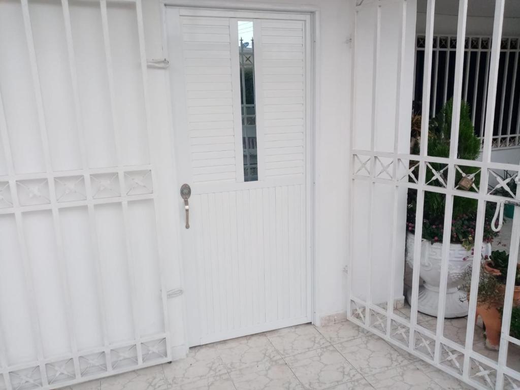 eine weiße Tür mit einem Fenster auf einem weißen Haus in der Unterkunft HABITACION CERCA DE LA UNIVERSIDAD DEL Sinu in Cartagena de Indias