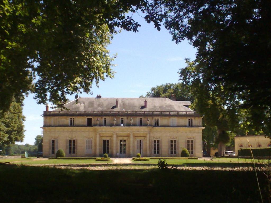 ein altes Haus in einem Park mit Bäumen in der Unterkunft Le Château de BRESSEY & son Orangerie in Bressey-sur-Tille