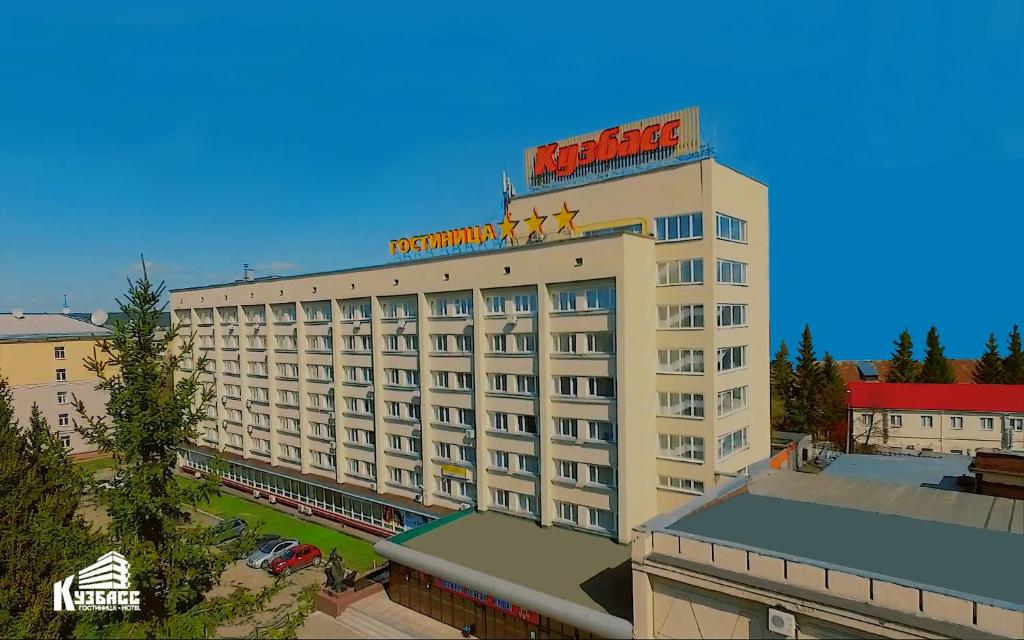 een hotelgebouw met een bord erop bij Hotel Kuzbass in Kemerovo