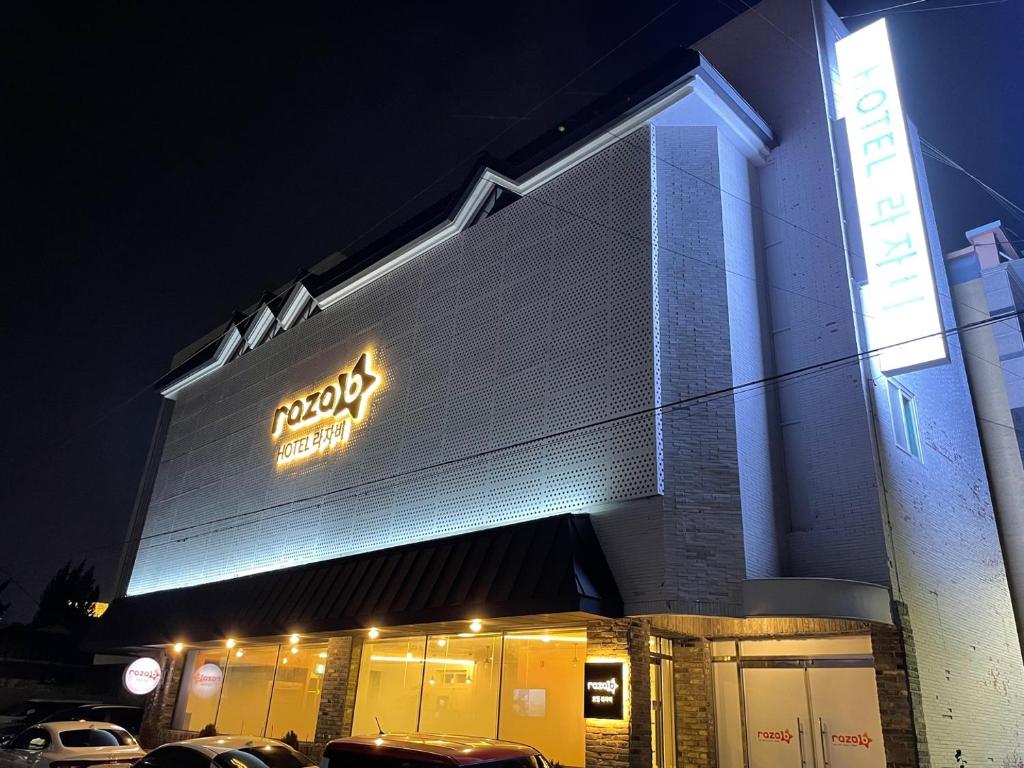 a building with a neon sign on the side of it at Hotel razaB in Pohang