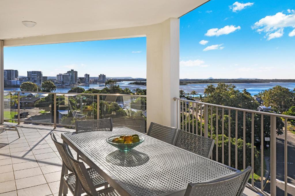 a dining room table with a balcony overlooking a city at Rovera Apartments in Maroochydore