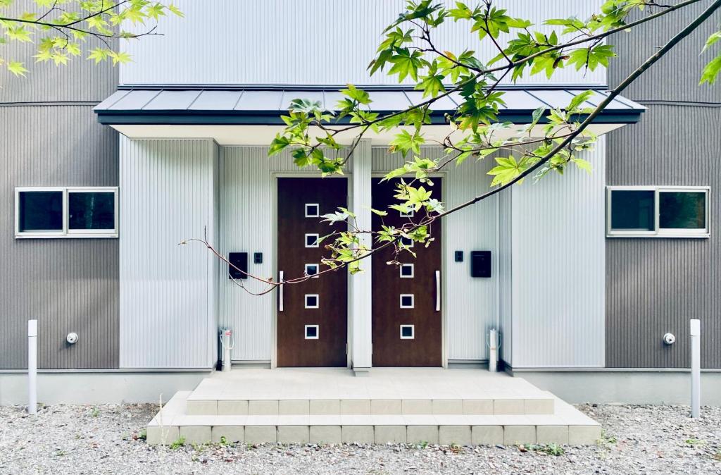 un edificio con una puerta marrón y blanca en Chalet Villars, en Hakuba