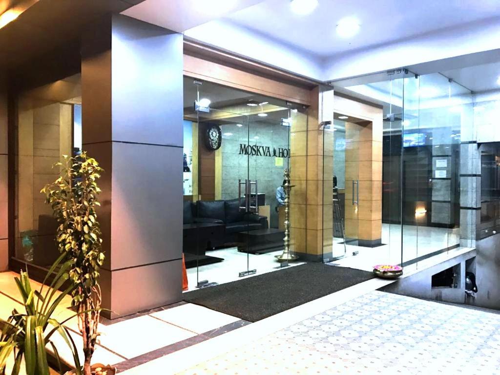 a lobby of a building with a clock on the wall at Moskva Hotel in Madurai