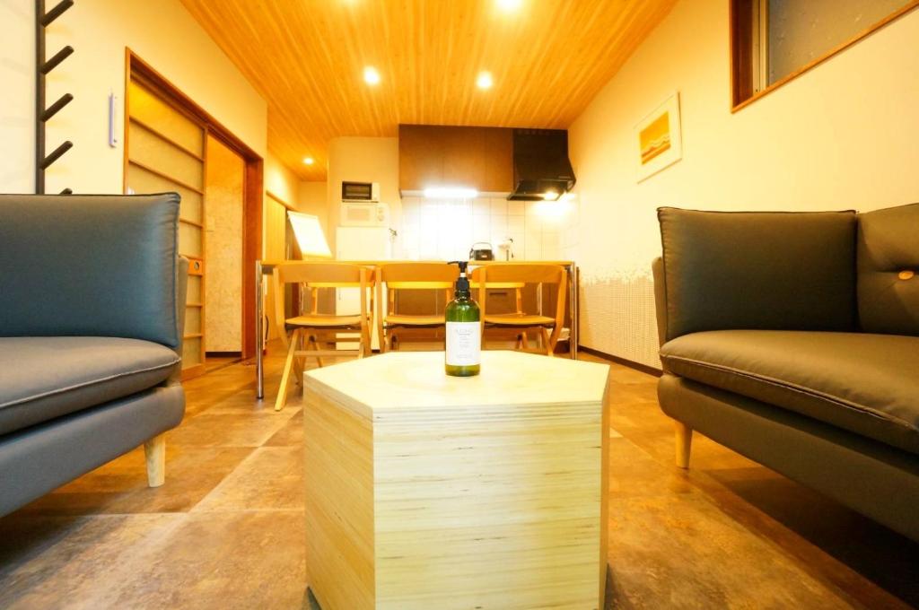 - une chambre avec 2 chaises et une bouteille de vin sur une table dans l'établissement Momiji Takayama, à Takayama