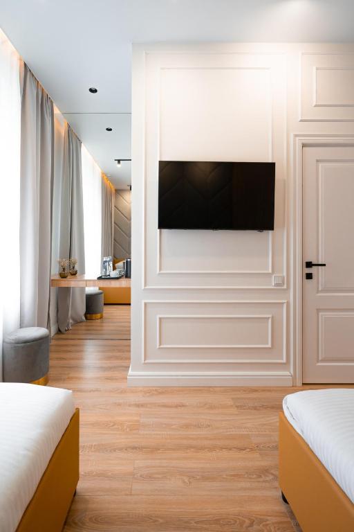 a room with two beds and a television on a wall at Suite Hotel in Kemerovo