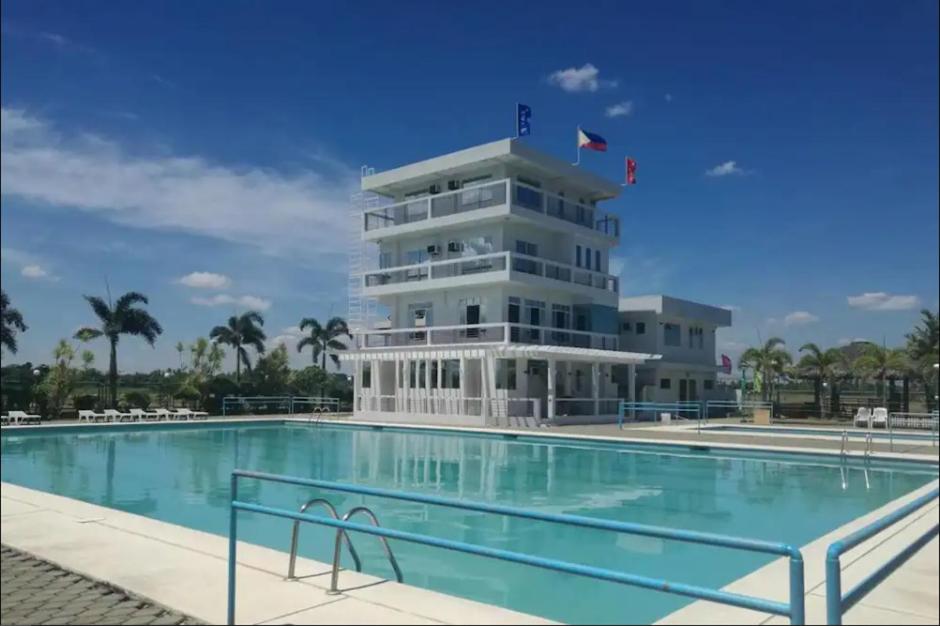 a building with a swimming pool in front of a building at RedDoorz Plus @ Green Star Park Cagayan in Ziminila