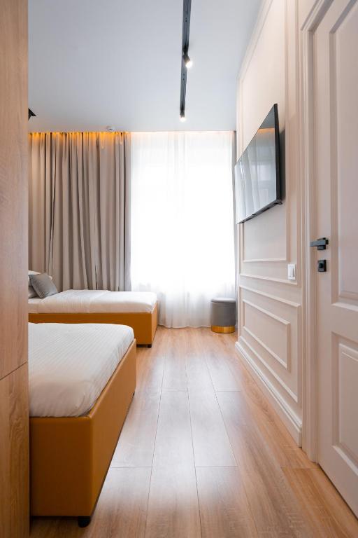 a hotel room with two beds and a television at Suite Hotel in Kemerovo