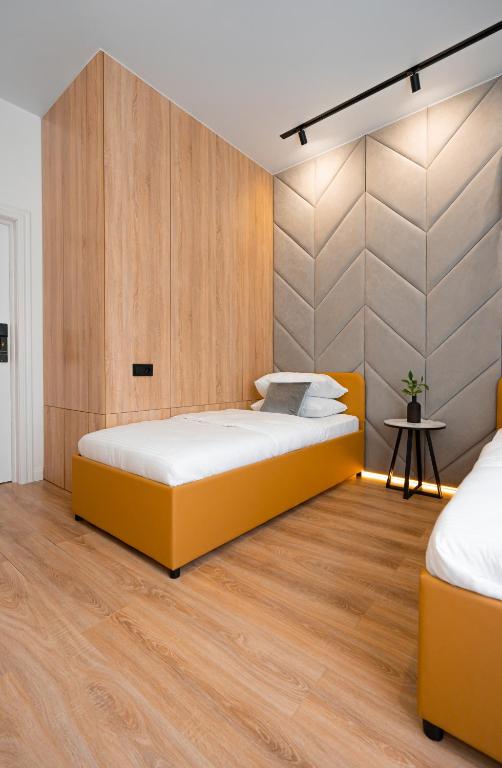 a bedroom with two beds and a wooden wall at Suite Hotel in Kemerovo