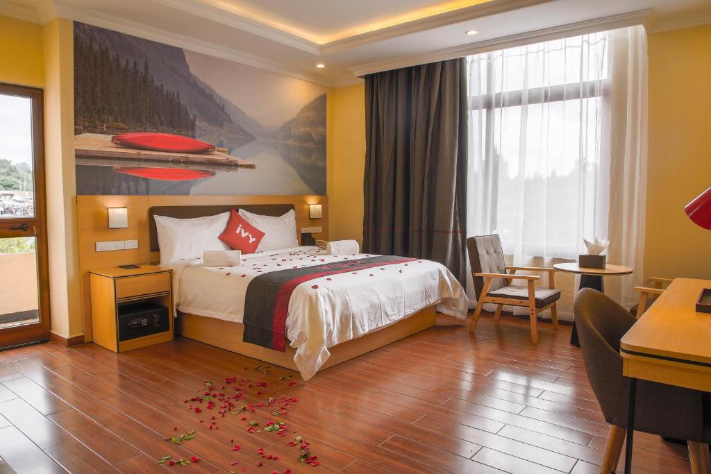 Habitación de hotel con cama, mesa y sillas en Ivy Hotel, Bishoftu, en Debre Zeyit