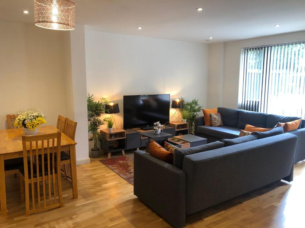 a living room with a couch and a tv at FW Haute Apartments at Queensbury, Ground Floor 2 Bedrooms and 2 Bathrooms with King or Twin beds with Front Porch and FREE WIFI and FREE PARKING in Wealdstone