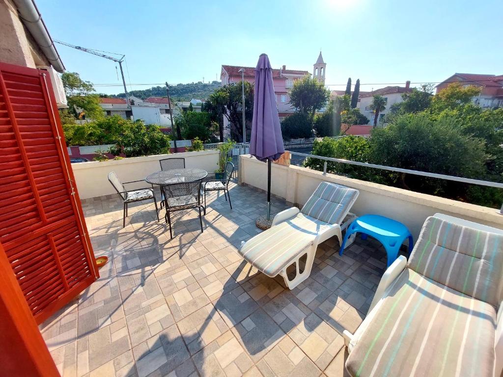 a patio with a table and chairs and an umbrella at Apartman Sunce in Murter