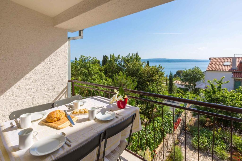 a table on a balcony with a view of the ocean at Two-Bedroom Apartment in Crikvenica XXXIII in Dramalj