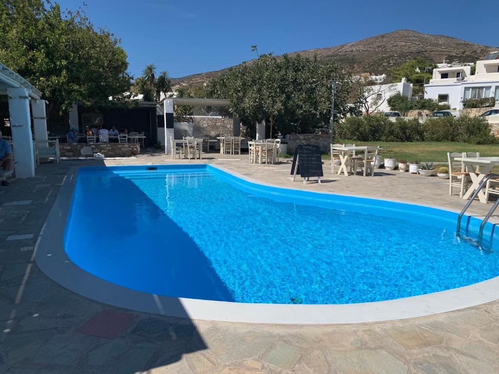 einen großen blauen Pool mit Tischen und Stühlen in der Unterkunft Hotel Anezina in Drios