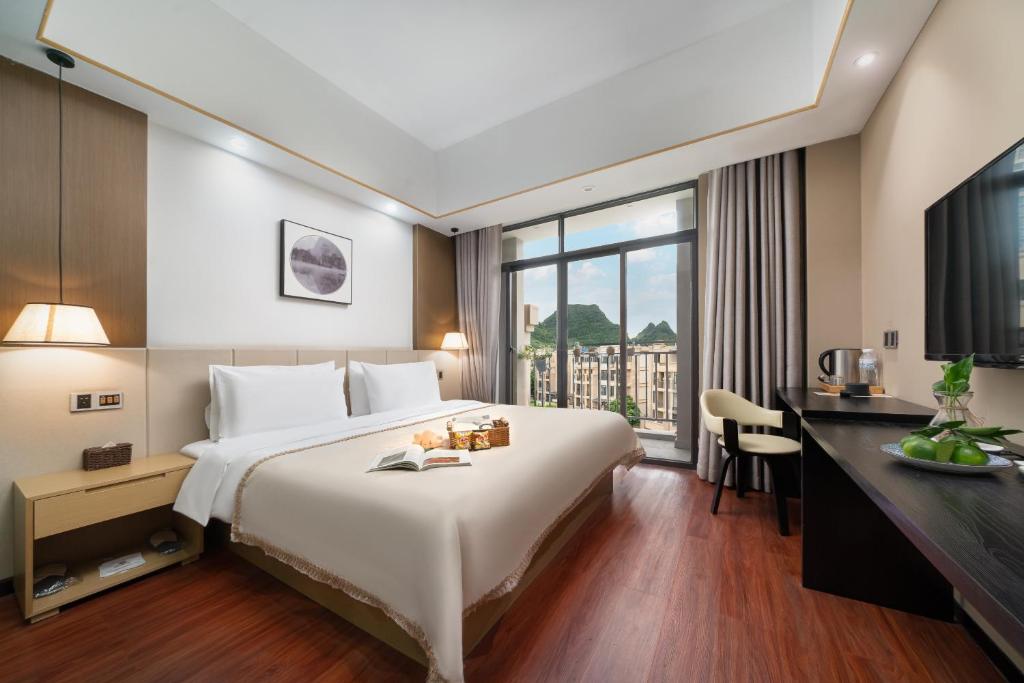 a hotel room with a large bed and a desk at Meeteem Boutique Hotel in Jingxi