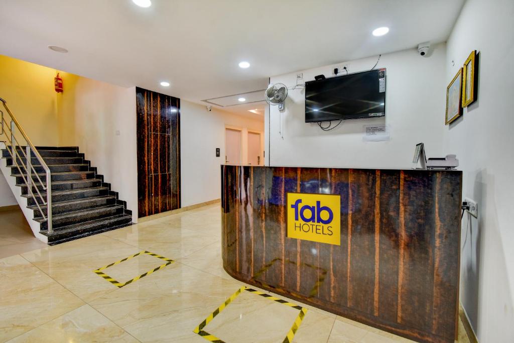 a view of a lobby with a tv and stairs at FabExpress P.A.S Residency in Chennai