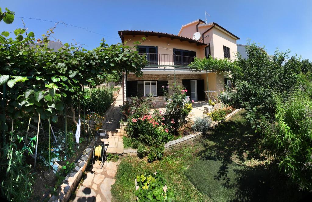 a house with a garden in front of it at Apartment Ema in Premantura