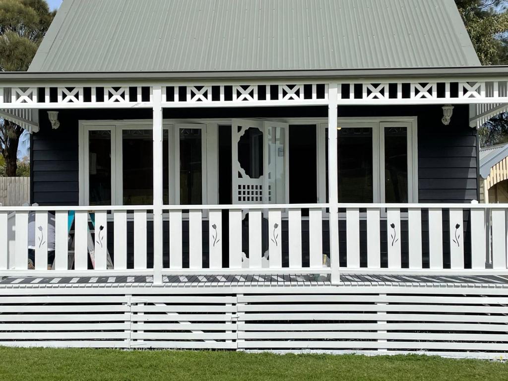 ein blaues Haus mit einem weißen Zaun davor in der Unterkunft Sandpiper - charming beach villa in Port Fairy