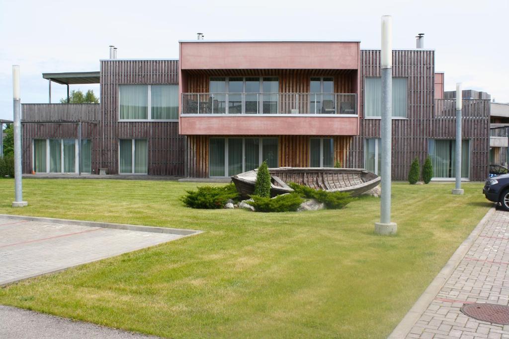 un bâtiment avec une cour d'herbe devant lui dans l'établissement Kuressaare Marina Apartment, à Kuressaare