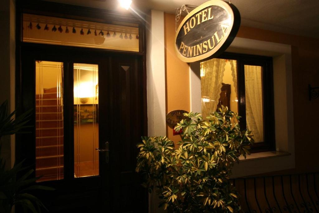 a hotel entrance with a potted plant in front of a building at Hotel Peninsula in Istanbul