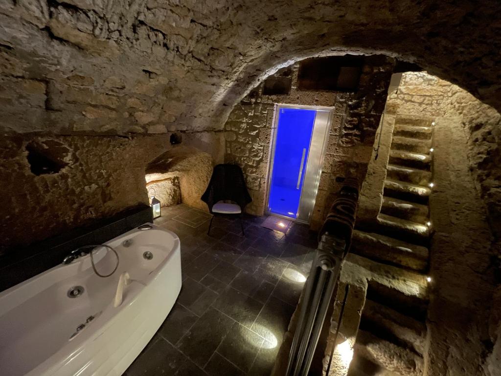 ein Badezimmer mit einer Badewanne und einem blauen Fenster in der Unterkunft Il Nido Etrusco in Orvieto