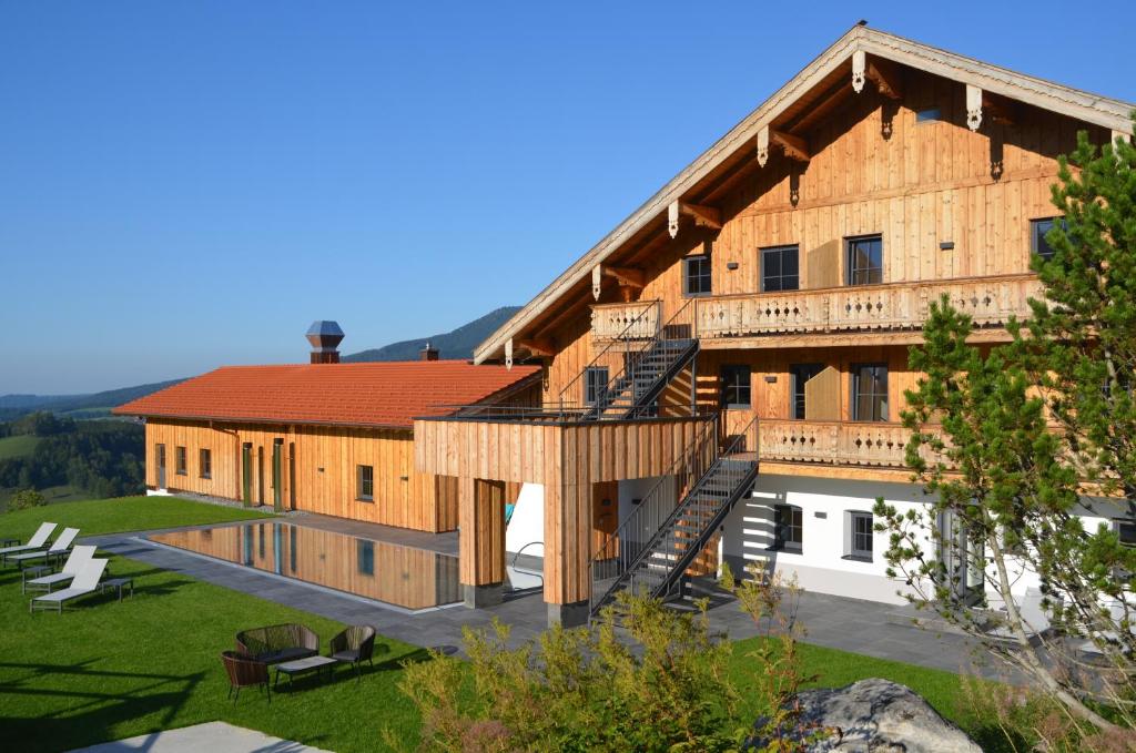 un gran edificio de madera con techo rojo en Unternberg Hof Ruhpolding en Ruhpolding