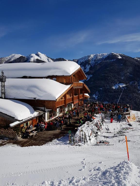 un grupo de personas de pie fuera de un lodge de esquí en Winklalm en Flachau