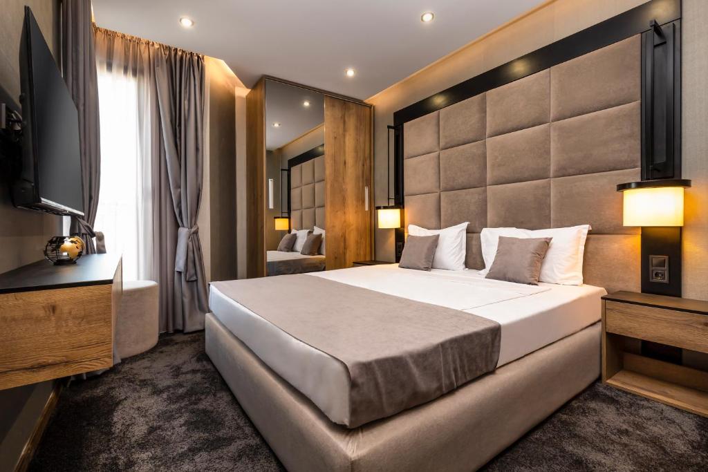 a hotel room with a large bed and a television at SOHO Apart House in Plovdiv