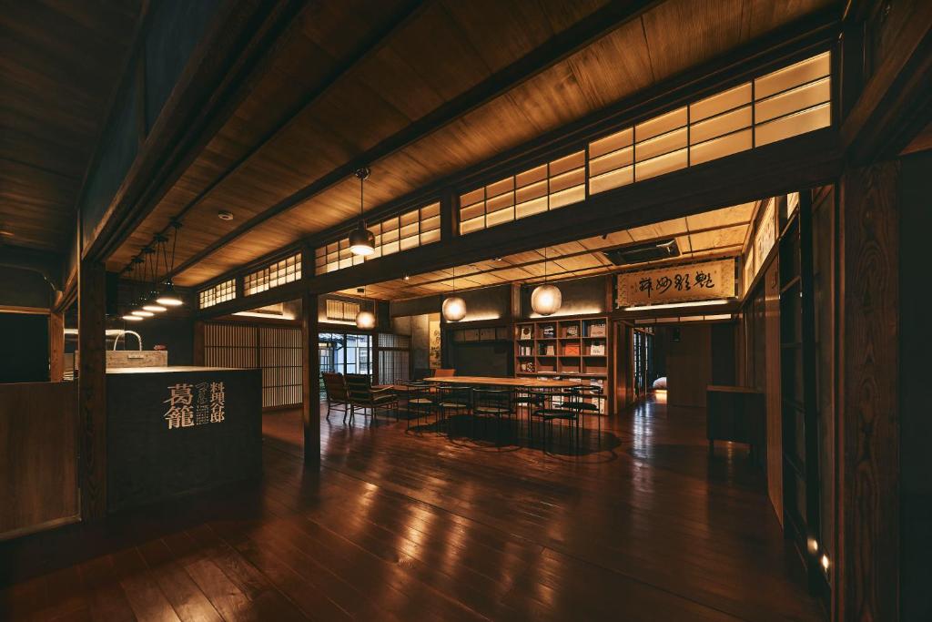 a large room with wooden floors and tables and windows at Tudzura in Kumamoto