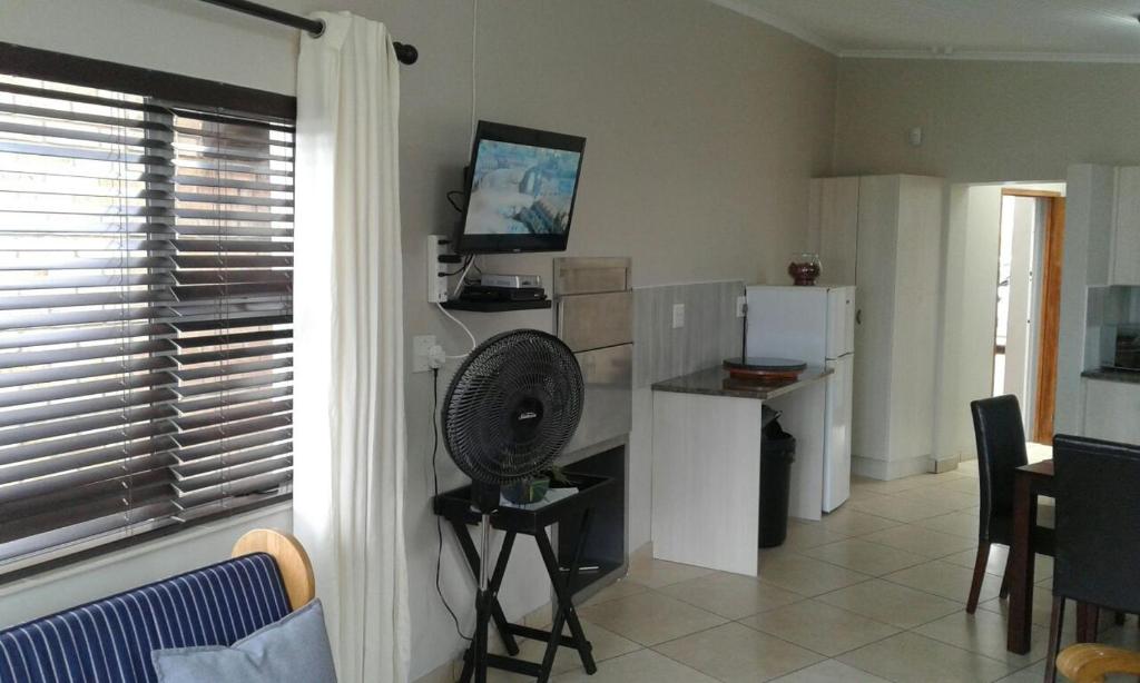 uma sala de estar com um frigorífico e uma ventoinha em Madiolyn em Jeffreys Bay