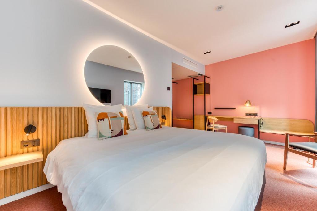 a bedroom with a large white bed and a desk at Mah Hotel in Saint-Ghislain