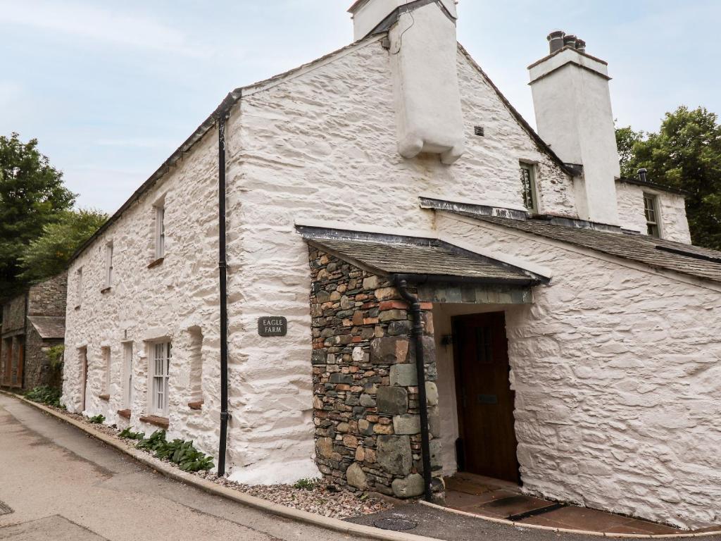 an old stone building with a door on a street at Eagle Farmhouse in Glenridding