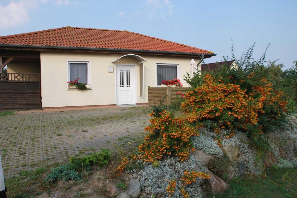 a small white house with flowers in front of it at Ferienhaus Guenter in Gager