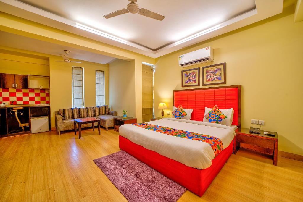 una camera con letto rosso e un soggiorno di FabHotel Rivlet a Gurgaon