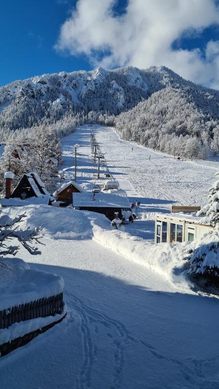 una montaña cubierta de nieve con una estación de esquí a lo lejos en Apartments Vijolica en Kranjska Gora